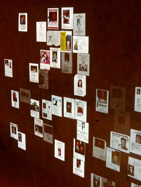 A panel of gradually changing Missing Flyers are projected in the exhibit.