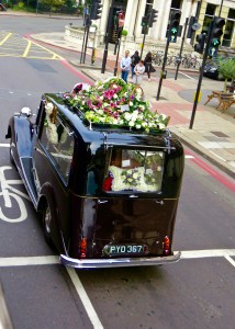 A British Hearse leading a funeral procession.