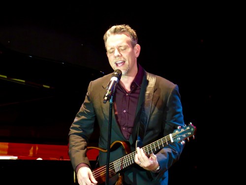 Adam Pascal accompanying himself on guitar.